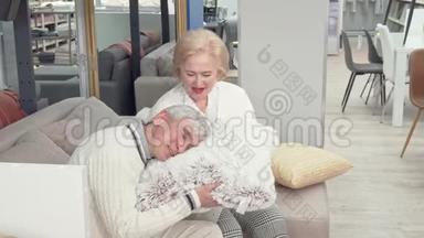 可爱的老夫妇在家具店挑选新的垫子